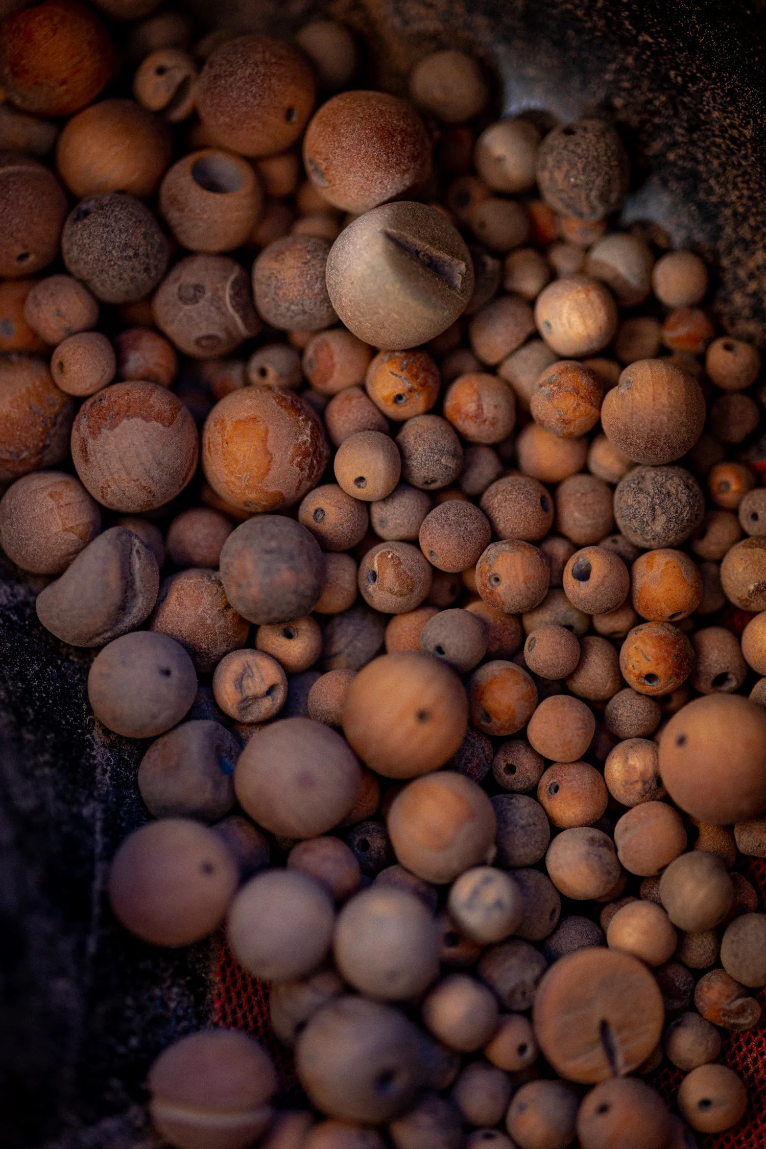 Hundreds of irregular unfinished cypress beads, dusty from sanding