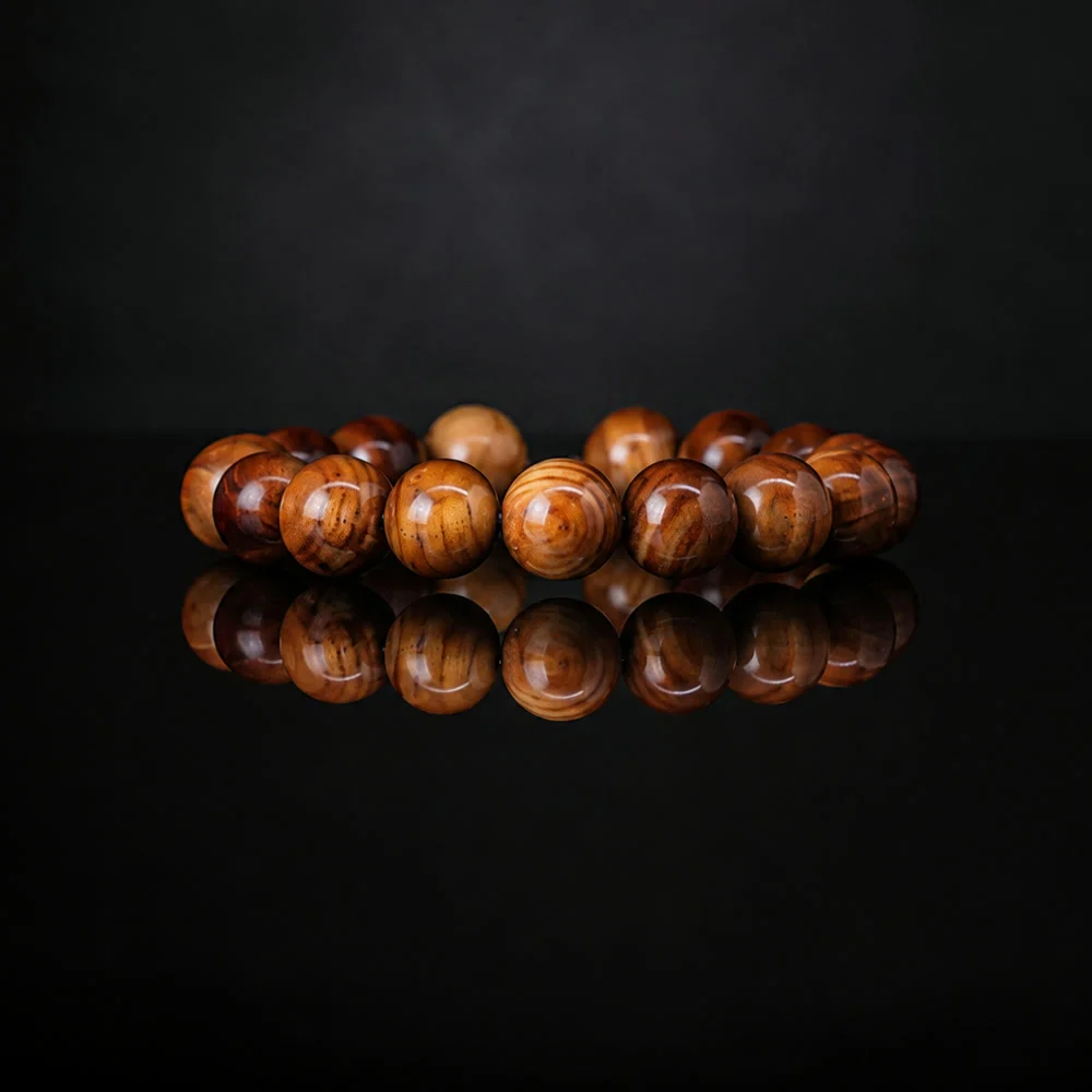 Polished cypress beads mirrored on black glass